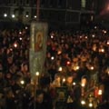 Золото икон, песнопения, свечи в руках прихожан
